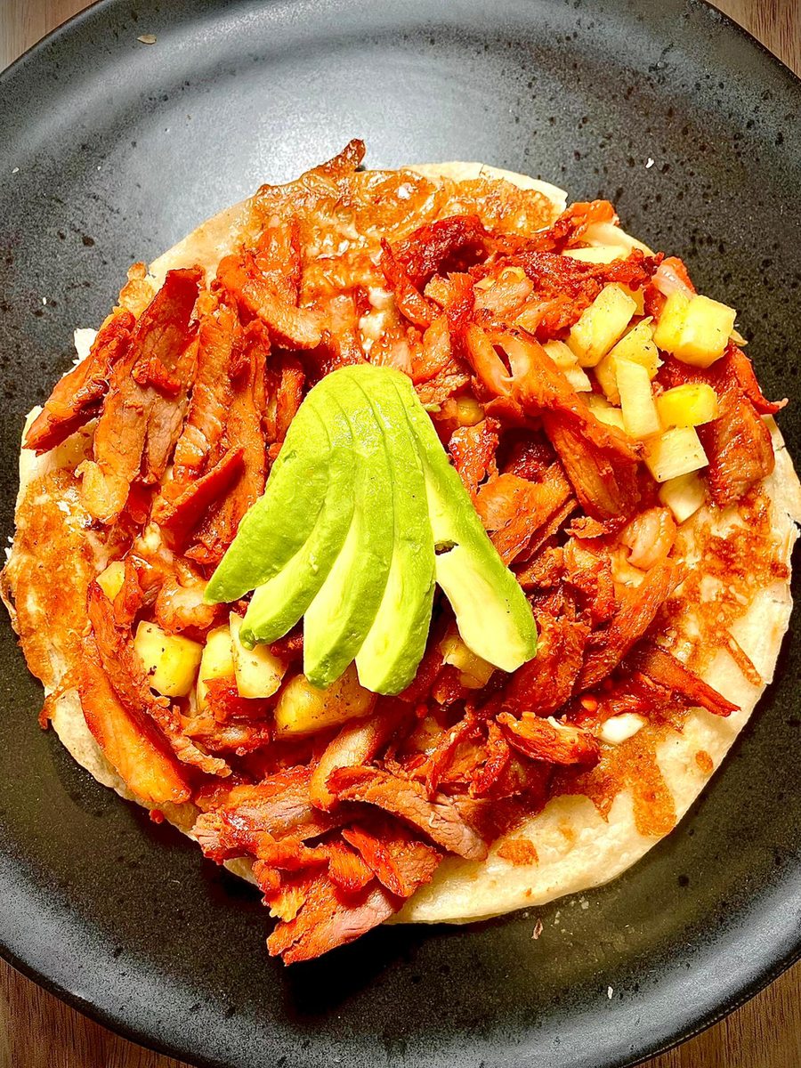 Tacos al pastor carved off the trompo